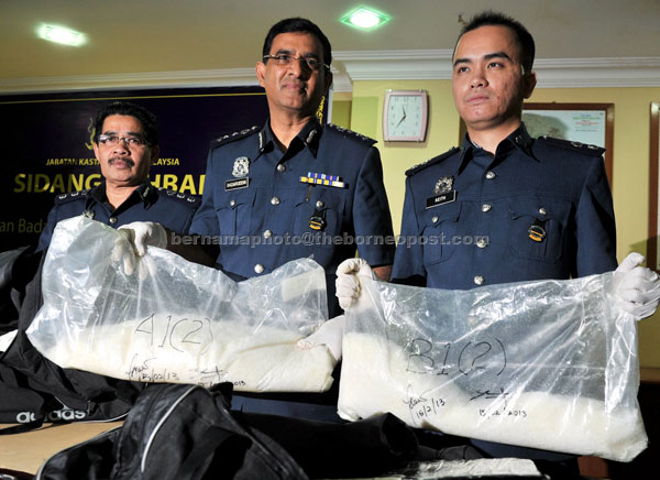 FOILED: Badaruddin (centre) and his men showing the seized drugs. — Bernama photo