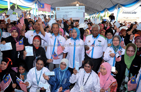 HEALTH SCREENING VOUCHERS: Muhyiddin with workers of Freescale Semiconductor (M) Sdn Bhd  who received Socso medical vouchers after launching the health screening programme at the company premises. — Bernama photo