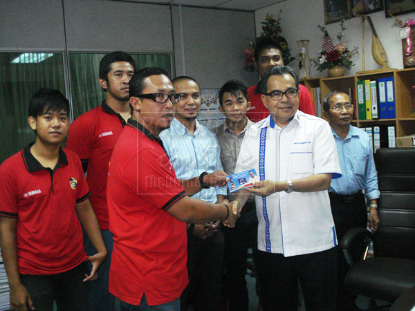 SUPPORT RESPONSIBLE RACING: Ahmad Lai (right) presents a donation to one of the groups representing Miri in the upcoming championship in Kuala Lumpur.