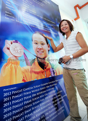 LATEST ACCOLADE: Pandelela touches a poster of herself during her visit at the Sarawak Aquatic Centre in Kuching, in this Aug 28, 2012 file photo. — Bernama photo