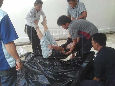 MALANG: Beberapa anggota polis mengangkat mangsa yang sudah tidak bernyawa untuk dibawa ke hospital bagi bedah siasat.