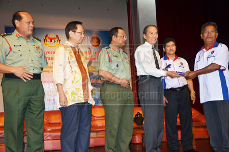 BANTUAN: Tiong (tiga kanan) menyampaikan baucar bantuan kepada veteran ATM yang tidak berpencen sambil diperhatikan oleh (dari kiri) Mundaw, Lau, Zulkiflee dan Ling di Sibu semalam.