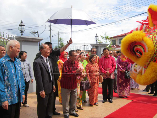 TRADITIONAL: Salahuddin (third left) and his entourage being greeted with a lion dance on arrival at the residence of Wong Leong Ming (second left).