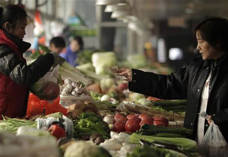 RIDING THE TIDE:  Photo shows a consumer purchasing vegetables at a market. The report says that inflation is expected to remain subdued in most of East Asia, but is still a concern for most countries in South Asia.