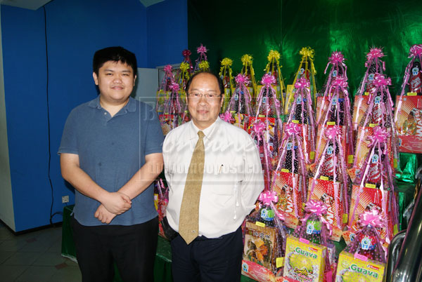 NEW HEIGHTS: Poh (right) is pictured with Justin Sim, personal assistant to Cha Yi director with festive hampers for Chinese New Year. Cha Yi has scaled to new heights via its core business philosophies and impeccable product placement via carefully-conducted market research.