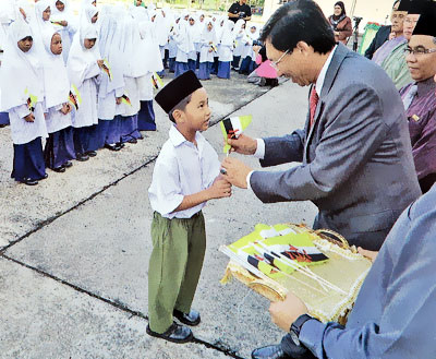 Minister of Culture, Youth and Sports handing over a flag to a student. 