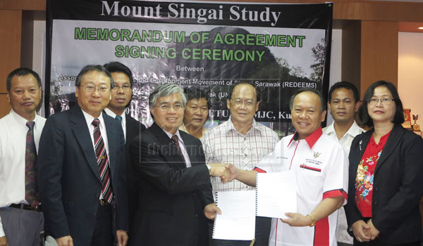 MEMORANDUM OF AGREEMENT: Khairuddin (third left) and Nansian exchanging the documents, witnessed by those present. 