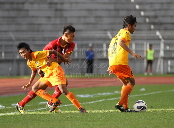 OH NO YOU DON’T: Sarawak (in red) struggling to gain ball possession in a losing cause against Pulau Pinang yesterday.