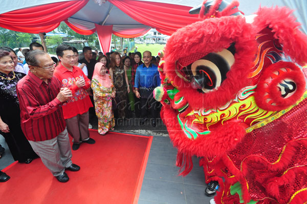 TRADITIONAL CHINESE CEREMONY: Salahuddin (left) and Norkiah (third left) are welcomed with a lion dance performance at the residence of Lee (second left) in Sibu.