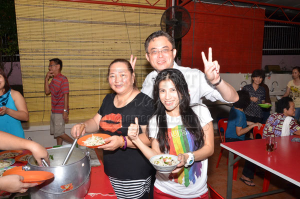 CHEERS: Tan Kai (back) with Number and a temple volunteer as they prepare Pa Mee. 