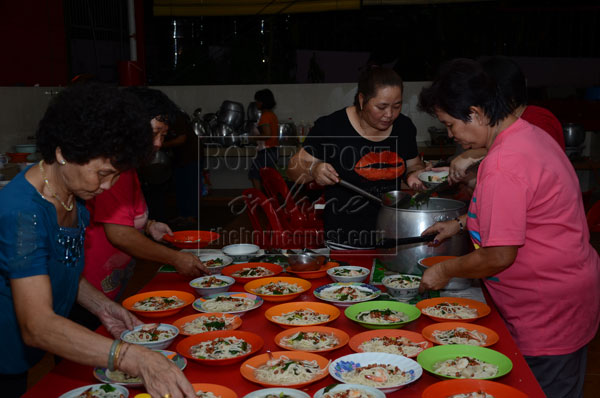 HELP YOURSELF: Volunteers helping to prepare Pa Mee for visitors at the back of the temple. 