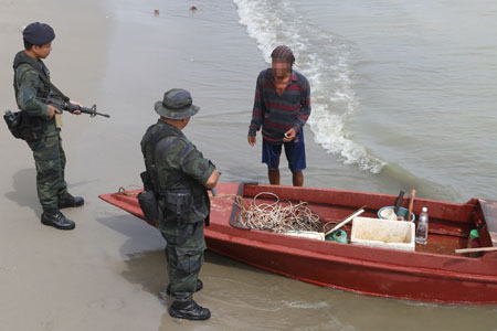 DUA anggota PGA melakukan pemeriksaan terhadap seorang nelayan di pantai Felda Sahabat 16 kelmarin.  