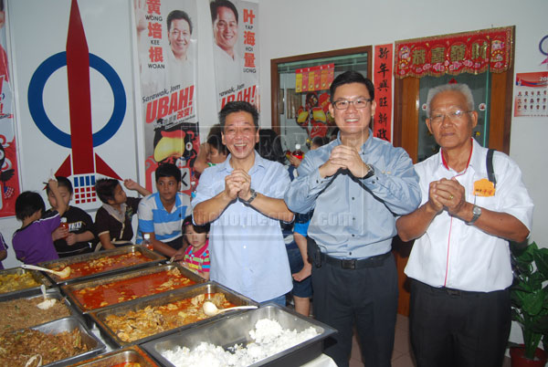 FESTIVE GREETINGS: Wong (left) and Ling wishing visitors a Happy New Year at the DAP open house.