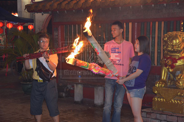 CARRYING ON TRADITION: A group of youths burn joss sticks. 