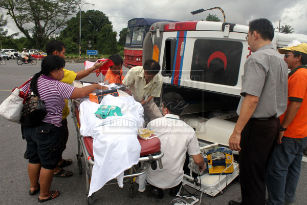 CLOSE SHAVE: Passengers including the critically ill patient are helped out of the ambulance unhurt.