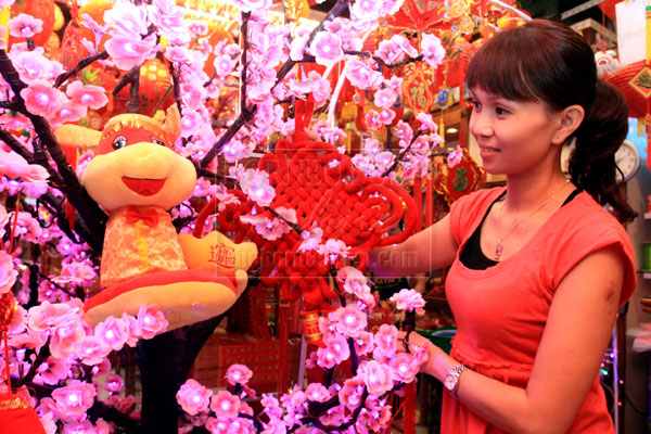 KUCHING: The daughter of Katai’s proprietor arranges New Year decoration at the shop in Kuching with the snake in the limelight this year. The Lunar New Year, also known as the Spring Festival, begins on February 10 and marks the start of the Year of the Snake, according to the Chinese zodiac. — Photo by Jeffery Mostapa