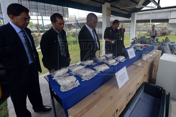 Noor Rashid (third left) inspecting some of the materials used by the syndicate to process the drugs.