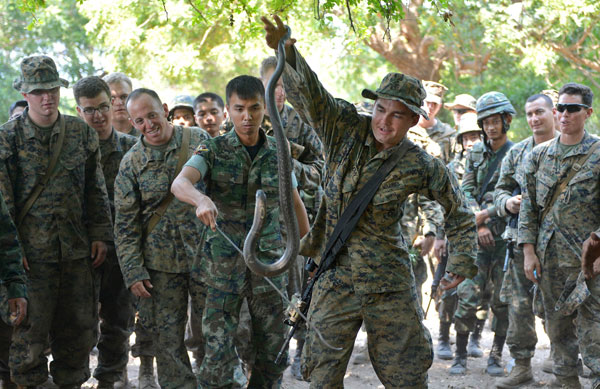 JUNGLE SURVIVAL EXERCISE: A US Marine holds a cobra during a jungle survival programme as part of the annual combined military exercises, Cobra Gold 2013, at a navy base in Sattahip yesterday. Cobra Gold is a joint, multi-national military training exercise that focuses on maintaining and improving military-to-military relationships among nations sharing common goals and security commitments in the Asia-Pacific region, including the US, Thailand, Singapore, Indonesia, Japan, South Korea and Malaysia. — AFP photo