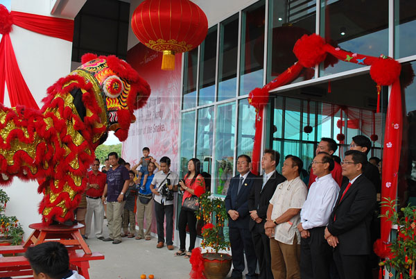 PROJECT LAUNCHED: Hasmi (centre), flanked by Yong (second right) and other senior officers, witnessing the lion dance performance during the launching ceremony of Naim Sales Gallery in Bintulu.