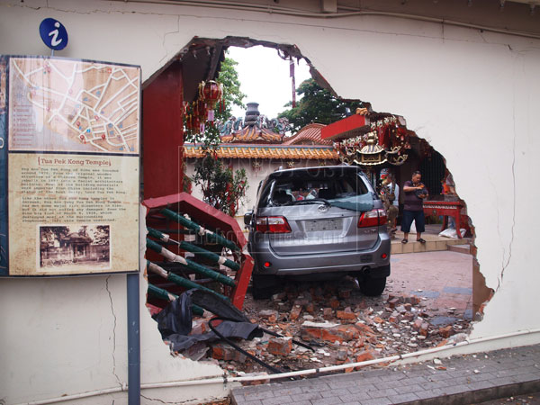 FREAK ACCIDENT: The car lands at the courtyard after it crashed through the temple wall.