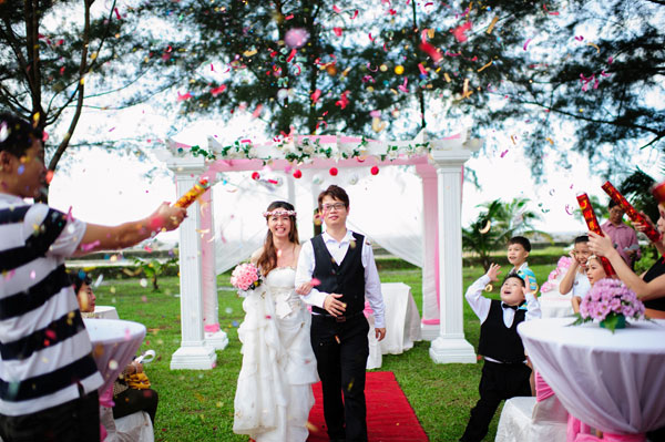 OUTDOOR CELEBRATION: Newlyweds Chet Voon and Ai-Lynn walk down the red carpet at the resort. — Photo by Nigulax Liew. 