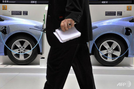A man walks past a wall showing the electric car system at the French carmaker Renault's booth on March 2, 2011. (AFP/File - Fabrice Coffrini)  