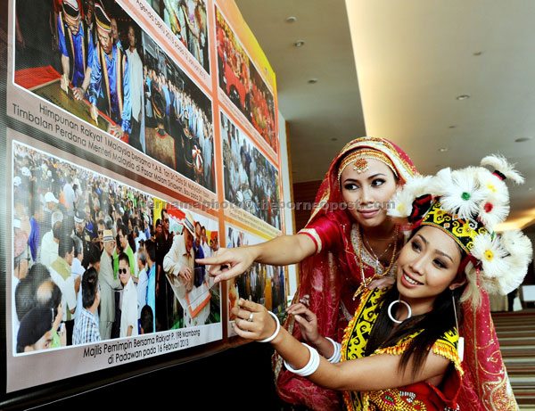 INTERESTING: Dancers from the Department of Culture and Arts Azlin Rebi (right) and Stephanie Morsheila David Dumbang look at  photos depicting the history of Chief Minister Pehin Sri Abdul Taib Mahmud from 1981 till the present at an   exhibition  held in conjunction with a public lecture in Kuching. — Bernama photo