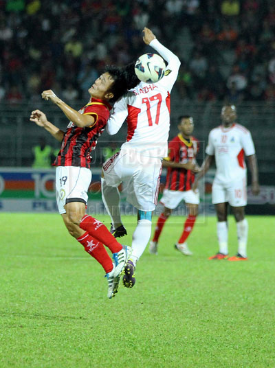 MIDFIELD TUSSLE: Sarawak’s Josep Kallang Tie vies for the ball with Sabah’s Shahrul Azhar Ture during their Premier League match at the State Stadium last night.