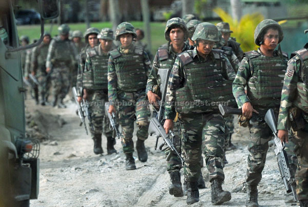 GEMPUR: Anggota tentera bersiap sedia ke Kampung Tanduo untuk menghadapi penceroboh yang masih berkubu di kampung itu di Lahad Datu, semalam. — Gambar Bernama