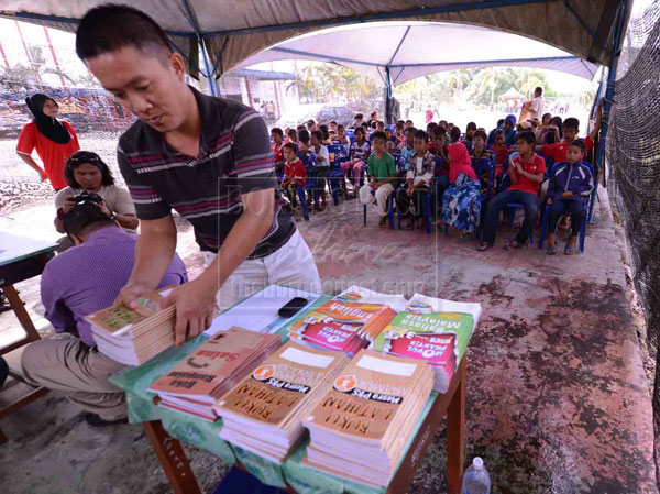 READY TO TEACH: A teacher arranging the textbooks before distributing them to the pupils. 
