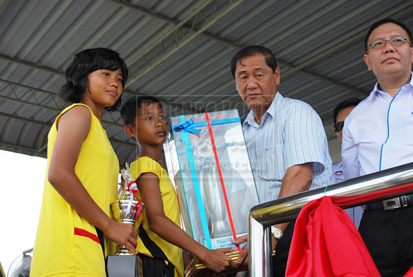BIG TIME: Pau presents the challenge trophy to representatives from Zone Sebauh as Tan (right) looks on. 