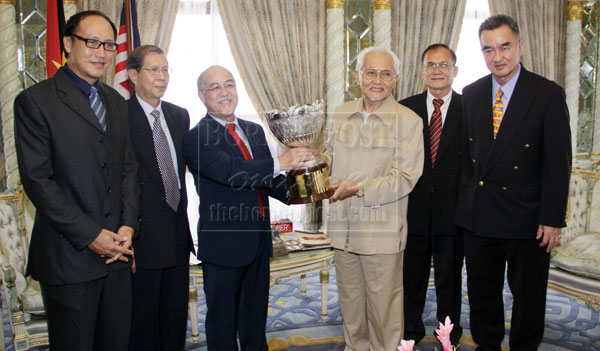 OVER TO YOU: Taib handing over the 21st Sarawak Chief Minister’s Cup to Liew (third left). — Photo by Muhammad Rais Sanusi