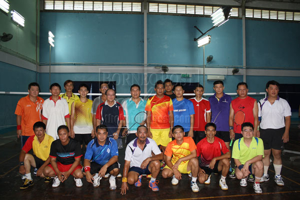 MAY THE BEST TEAM WIN: Standing at fifth and sixth left were Kapitan Micky Ngu and DSP Entusa Iman with the players from both teams before the start of the friendly badminton tourney between the police and the public.