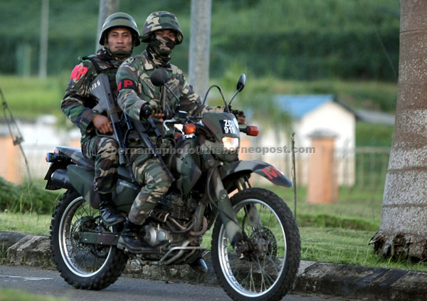 MOBILITY AND SPEED: Two soldiers on patrol duty using a motorbike. 