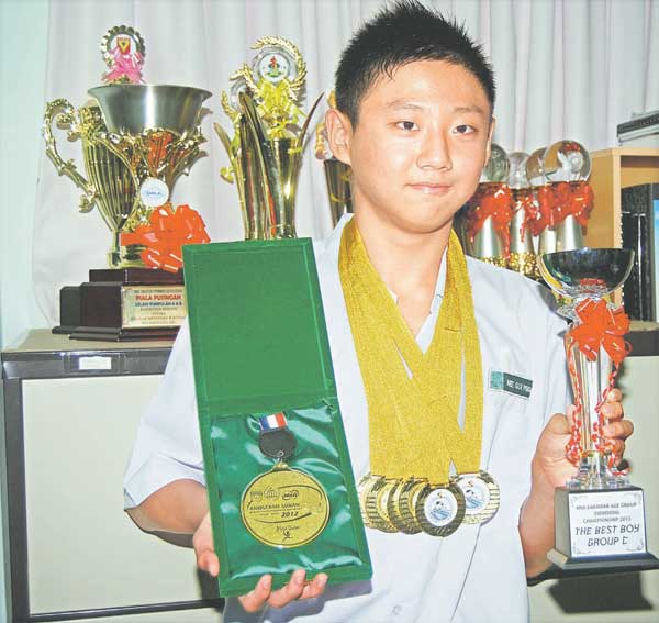 OUTSTANDING: Gui Ping with his Most Promising Swimmer Award, trophies and medals.