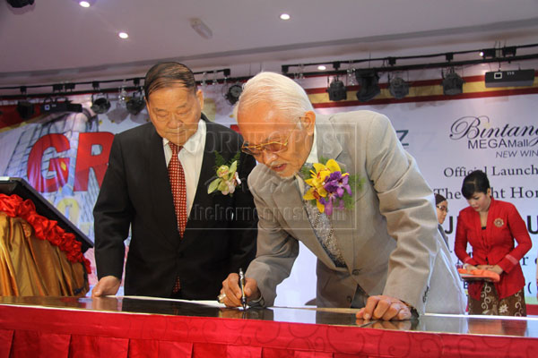 FOR THE RECORD: Taib signing a plaque to commemorate the simultaneous opening of Meritz Hotel, Parkson, GSC and Bintang Megamall New Wing.  