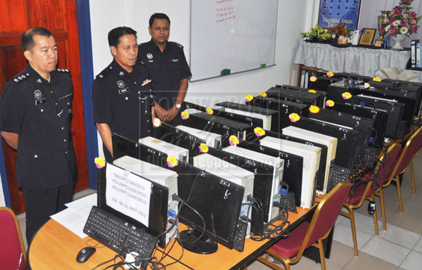 Robert (centre) with his senior officers showing the seized computer sets.