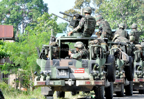 MOPPING UP: Members of the Malaysian armed forces on the look-out for remnants of the armed Sulu terrorists in Tanjung Batu . — Bernama photo