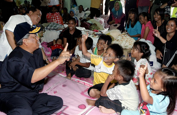 BRINGING CHEER: Muhyiddin shares a light moment with children during his visit to Dewan Serbaguna Cederawasih. — Bernama photo