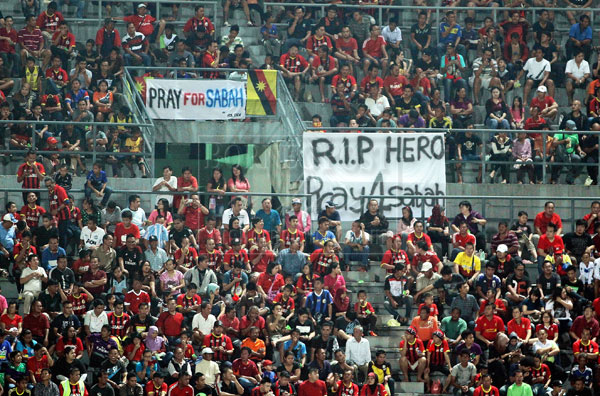 NATIONAL SOLIDARITY: Sarawak football fans hoist banners calling for prayers for Sabah and fallen servicemen during a Premier League match between the two state teams in Kuching. Appropriately the match last night ended in a 0-0 draw. — Photo by Chimon Upon  l  Full match report backpage
