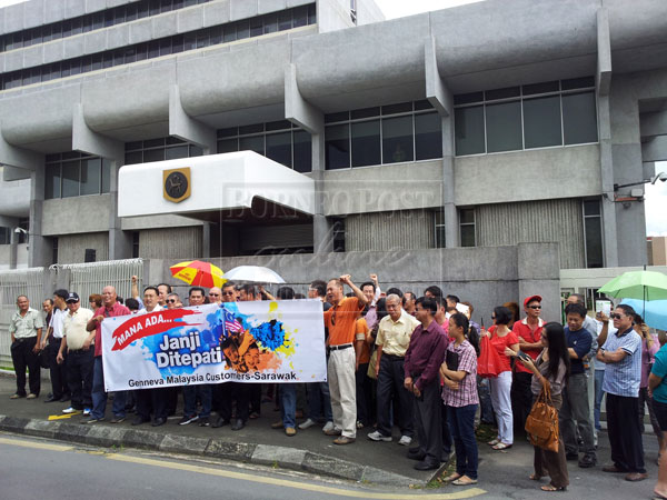 DEMAND FOR AN ANSWER: Chong (right) together with some of the investors in front of Bank Negara Malaysia before handing over a memorandum to the bank’s official.  