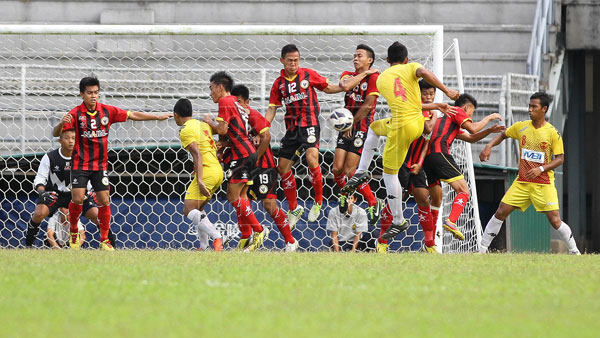 GOAL MOUTH MELEE: Sarawak’s President Cup team (in red) in tight formation during the free kick taken by Selangor players in their match played at State Stadium, Petra Jaya yesterday. The match ended in a scoreless draw but the point in the bag helped to improve the Young Crocs’ position in the table standing. — Photo by Harry Ilias