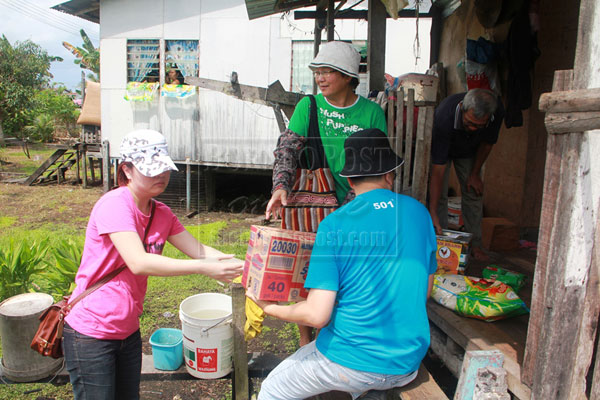 CARING GESTURE: Distributing goodies to the poor. 