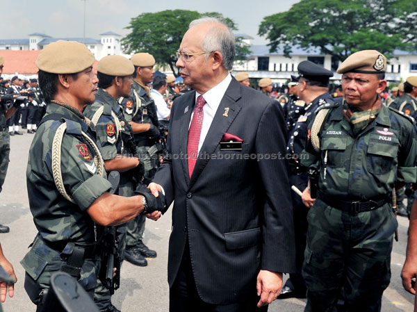 KEEP IT UP: Najib shaking hands with a VAT69 Commando at the 206th Police Day celebration. — Bernama photo