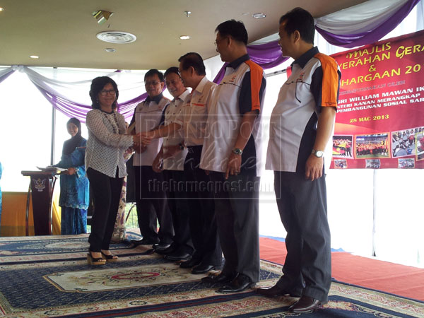 ALL THE BEST: President of Sarawak Women Hockey Association, Datin Mary Saadiah Zainuddin (left) greets Assistant Minister for Sports Datuk Lee Khim Sin after receiving the grant from Mawan (third left).