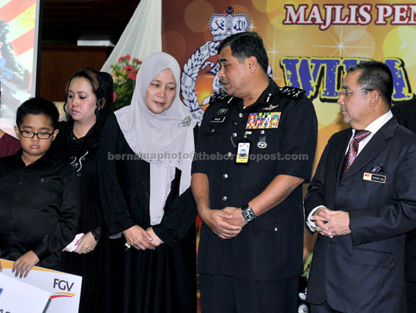 GIVING SUPPORT: Isa and Khalid (second right) talk to the widows of ACP Ibrahim Lebar, Rosiah Dahlan and DSP Michael Padel, Jabah Mingku (second left) after receiving donations from two companies for the families of the policemen.— Bernama photo