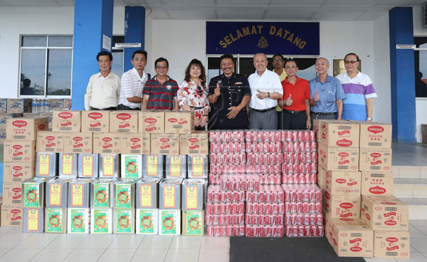 Gan (fifth right) presents the goods to Semporna police chief.