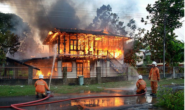 THE BLAZE AT ITS HEIGHT: Fire-fighters dousing the fire. 