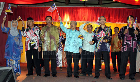 SEMARAKKAN KEMERDEKAAN: Mohammad Ali (tengah) ditemani Ismail (tiga kanan) dan tetamu lain mengibarkan bendera sempena Perayaan 50 Tahun Sarawak Merdeka Dalam Malaysia Peringkat Bahagian Samarahan 2013 di Dewan Suarah Kota Samarahan.