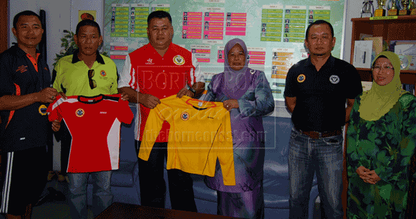 THIS ONE FOR YOU: Duke (third left) handing over the jersey to Zemrud as witnessed by Jeffery (left), Norjanah (right) and other committee members. 